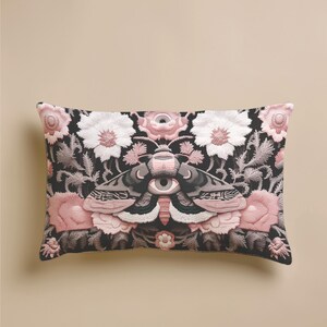 Gothic moth eye botanical lumbar pillow with mystical embroidered wings on dark fabric. Cottagecore throw pillow featuring protective moth symbol surrounded by pink roses, white wildflowers & sacred botanicals. Witchy home decor with medieval tapestry aesthetic. Perfect for dark academia spaces, bohemian decor & occult art lovers. 20x12 lumbar size.