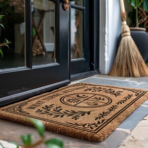Natural coir doormat featuring "What Turns, Returns" text with sacred elemental symbolism including sun, crescent moon, flames, and botanical sprigs arranged in protective circular mandala design. Four classical elements represented in quadrants surrounded by intricate corner flourishes and leafy botanical borders. Perfect witchy welcome mat for pagan home decor, spiritual protection, and mystical entryway styling.