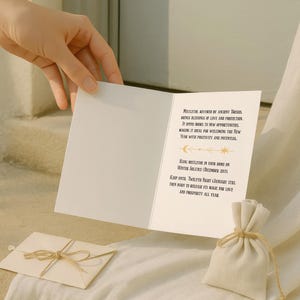 Luxurious black Yule card featuring golden mistletoe design, moon phases, and stars. "Mistletoe" and "For Protection & New Beginnings" in ornate gold text.