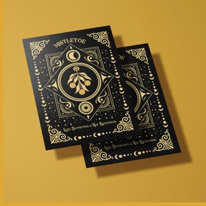 Luxurious black Yule card featuring golden mistletoe design, moon phases, and stars. "Mistletoe" and "For Protection & New Beginnings" in ornate gold text.