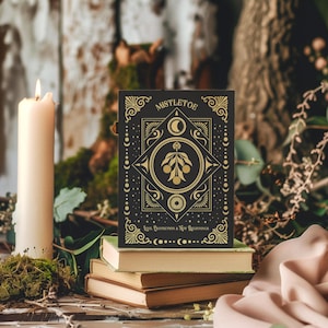 Luxurious black Yule card featuring golden mistletoe design, moon phases, and stars. "Mistletoe" and "For Protection & New Beginnings" in ornate gold text.