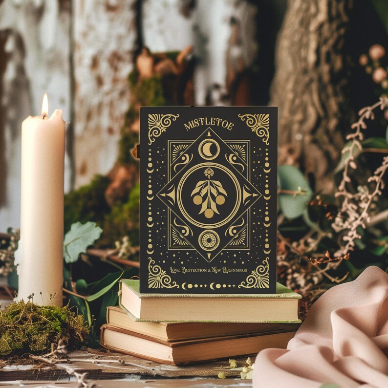Luxurious black Yule card featuring golden mistletoe design, moon phases, and stars. "Mistletoe" and "For Protection & New Beginnings" in ornate gold text.