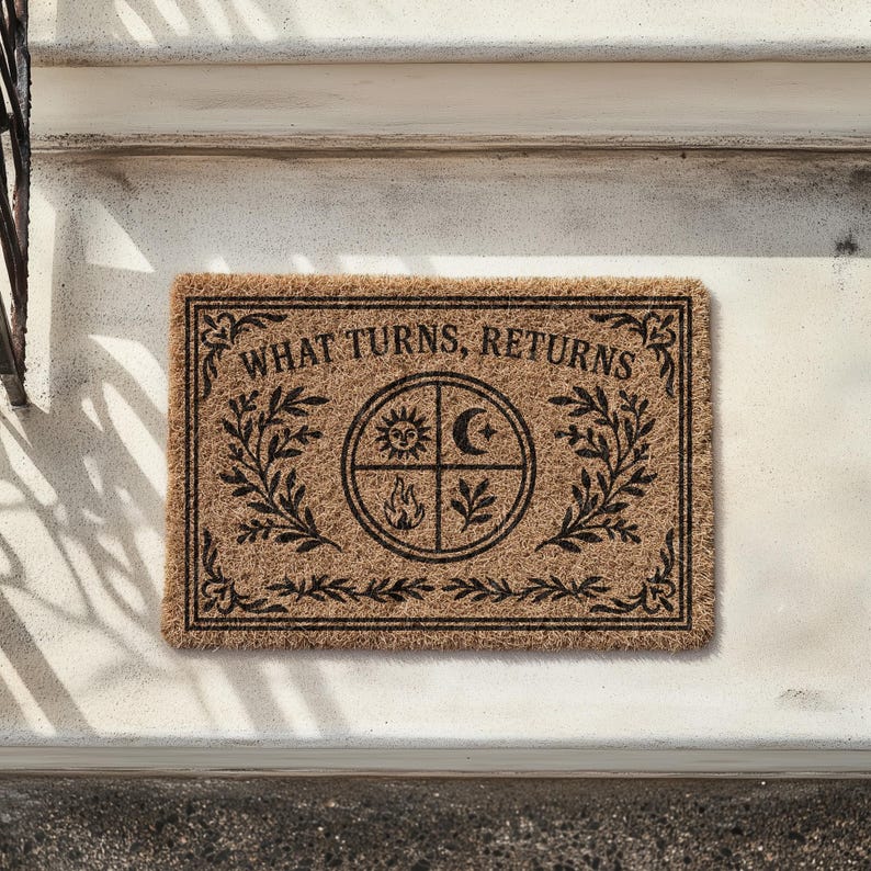 Natural coir doormat featuring "What Turns, Returns" text with sacred elemental symbolism including sun, crescent moon, flames, and botanical sprigs arranged in protective circular mandala design. Four classical elements represented in quadrants surrounded by intricate corner flourishes and leafy botanical borders. Perfect witchy welcome mat for pagan home decor, spiritual protection, and mystical entryway styling.