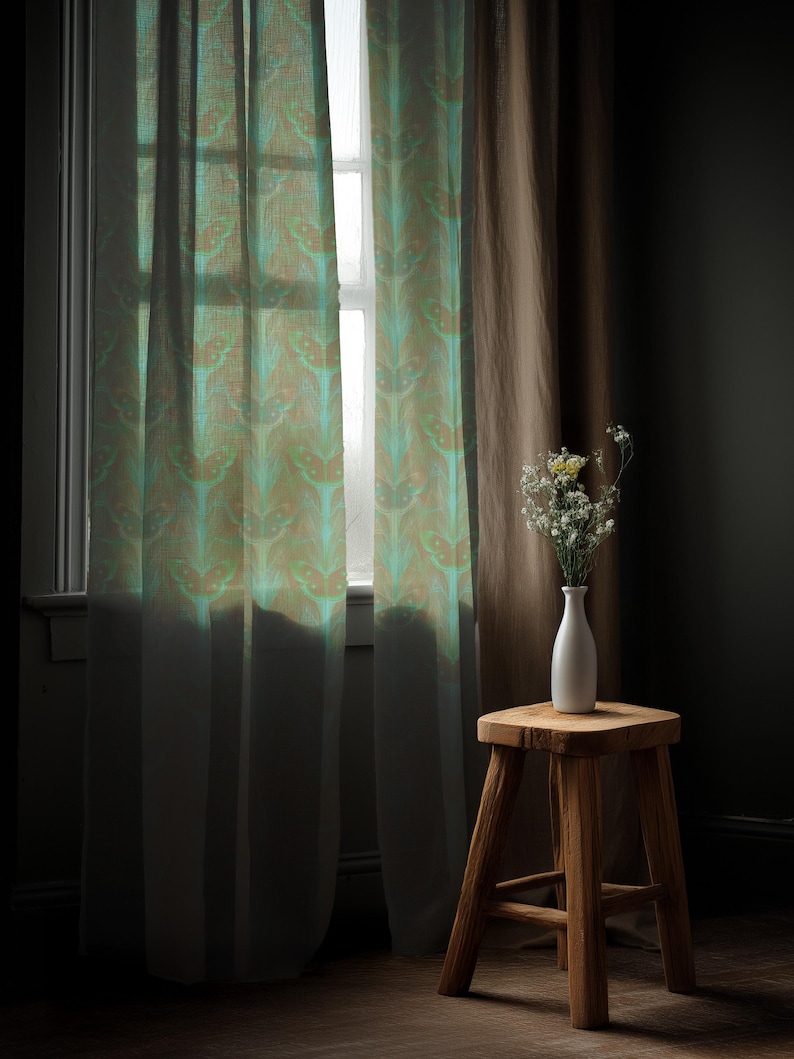 Sheer curtain panel featuring an intricate pattern of luminous emerald green Luna moths on an amber background. The design shows symmetrical rows of moths with delicate wing details and botanical elements in a vertical arrangement.