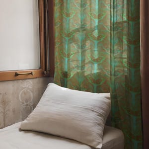 Sheer curtain panel featuring an intricate pattern of luminous emerald green Luna moths on an amber background. The design shows symmetrical rows of moths with delicate wing details and botanical elements in a vertical arrangement.