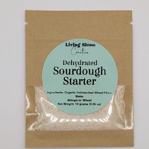 Könnte beinhalten: Ein Set aus drei Keramikbechern mit gesprenkelter, matter Oberfläche. Die Becher sind in Creme-, Hellgrau- und Dunkelgrautönen gehalten. Jeder Becher hat ein schlichtes, minimalistisches Design.