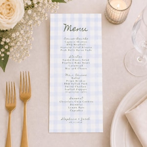 May include: A rectangular menu card with a light blue and white gingham pattern. The text lists courses including Amuse-Bouche, Starter, Main Course, and Dessert, with the names Stephanie & Jacob and the date 06.27.2026 printed at the bottom.