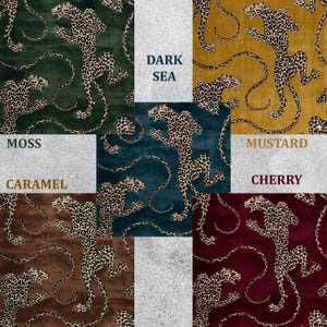 May include: A collection of patterned fabric samples featuring a leopard print design. The samples are in various colors, including moss green, dark sea blue, mustard yellow, cherry red, and caramel brown. Each sample has the color name printed on it.