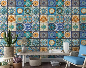 Puede incluir: Un interior de sala de estar con una pared cubierta con un papel tapiz estampado de colores que presenta un mosaico de azulejos azules, verdes, naranjas y amarillos. El papel tapiz tiene un diseño marroquí o de Oriente Medio. Una mesa de madera con un jarrón y libros se encuentra frente a la pared. Un sillón azul se encuentra en la esquina de la habitación.