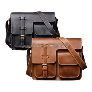 Peut inclure: Deux sacs messagers en cuir, l'un noir et l'autre marron. Les deux ont une forme rectangulaire avec une fermeture à rabat, deux poches avant et des bandoulières réglables. Les sacs ont des boucles métalliques et des détails de couture.