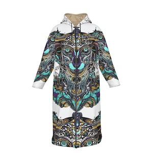 Puede incluir: Abrigo largo con capucha y diseño simétrico detallado. El abrigo presenta una base blanca con un patrón vibrante en turquesa, morado, dorado y negro. El diseño se asemeja a una cara de animal estilizada. El abrigo tiene una cremallera completa y un interior color beige.