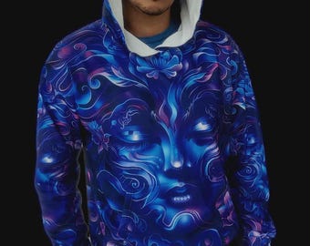 Puede incluir: Una sudadera con capucha y manga larga que presenta un estampado gráfico vibrante en azul y morado de un rostro estilizado con los ojos cerrados, rodeado de patrones abstractos y motivos florales, con un forro interior de capucha blanco.