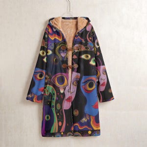 May include: A long coat with a hood, featuring a vibrant, abstract face pattern. The coat has a black base with faces in blue, purple, and red. It has a toggle fastening and a soft, tan interior lining.