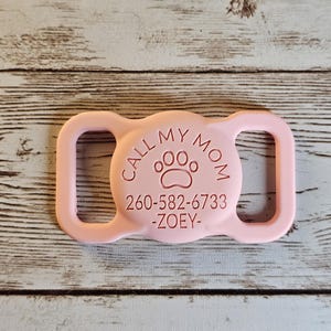 May include: Pink plastic dog collar buckle with the text "CALL MY MOM" and a paw print, along with a phone number and the name "ZOEY".