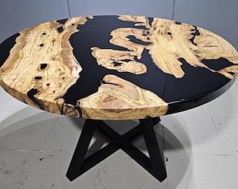 Könnte beinhalten: Runder Holztisch mit einer schwarzen Epoxidharzplatte und einem schwarzen Metallgestell. Die Tischplatte hat eine natürliche Holzmaserung.