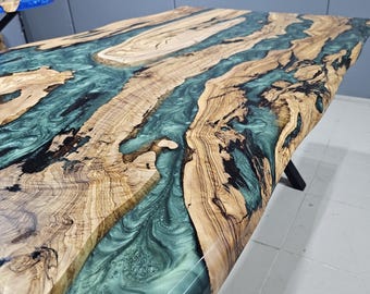 Könnte beinhalten: Nahaufnahme einer Tischplatte aus Holz mit einem durchlaufenden Fluss aus grünem Epoxidharz. Das Holz hat eine natürliche Maserung und das Harz einen wirbelnden Effekt.