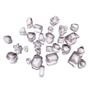 May include: A collection of clear glass crystals of various shapes and sizes, scattered on a white background.