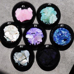 May include: Seven small jars with different colored iridescent shell pieces labeled #1 through #7.