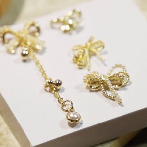 Delizioso gioiello a forma di papillon con catena in oro e perle