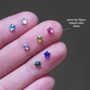 May include: Assortment of 4mm star-shaped rhinestones in various colours, including green, blue, pink, and white. Price for 50 pieces.