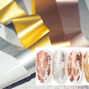 Pode incluir: Quatro tiras de esmalte para unhas com diferentes acabamentos metálicos: cobre, prata, ouro rosa e ouro. As tiras estão dispostas em uma fila sobre um fundo branco.