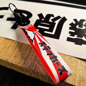 May include: A white ceramic mug with a black handle and the text "But First, Coffee" in a black, handwritten-style font. The mug is likely 11-15 ounces in size, perfect for a morning beverage.