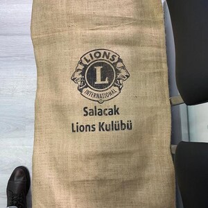 May include: A brown burlap sack with the Lions International logo and the text "Salacak Lions Kul&uuml;b&uuml;".