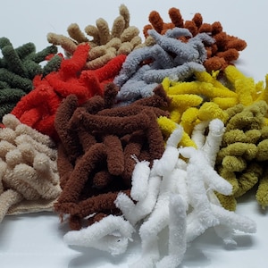 May include: Assortment of colorful chenille stems in various colors, including green, red, brown, beige, gray, yellow, and white. The stems are fluffy and soft, perfect for crafting.