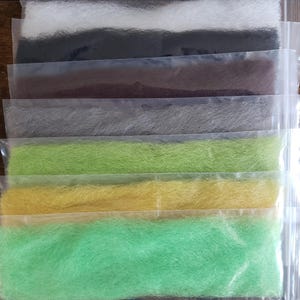 May include: A variety pack of colorful synthetic fur in individual clear plastic bags. The fur is arranged in rows, with each row a different color. The colors include white, black, brown, gray, green, yellow, and light green.
