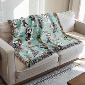 A cozy living room with a white sofa and a colorful throw blanket featuring various cartoon characters and holiday-themed designs.