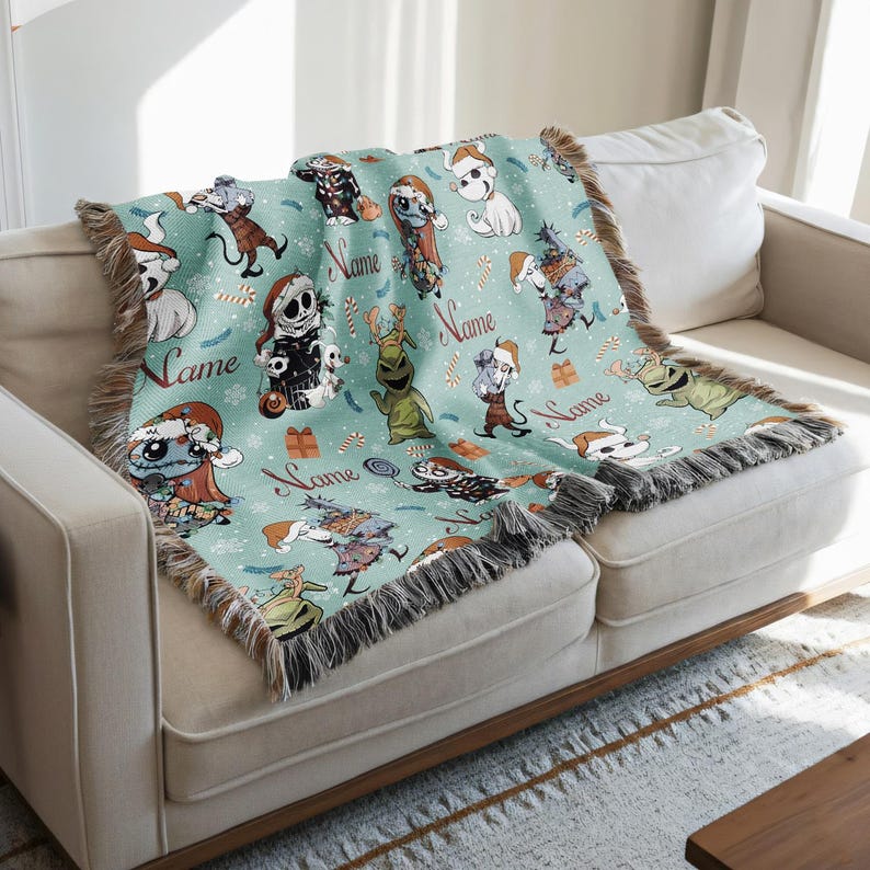A cozy living room with a white sofa and a colorful throw blanket featuring various cartoon characters and holiday-themed designs.