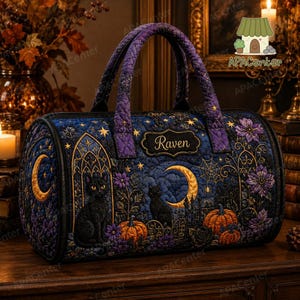 Könnte beinhalten: Eine gesteppte, zylinderförmige Reisetasche in Dunkelblau und Violett mit einem schwarzen Katzenmotiv, orangefarbenen Kürbissen, einer Mondsichel und Sternen. Die Tasche hat ein zentrales Etikett mit dem Namen Raven, zwei Tragegriffe und dunkle Kanten.