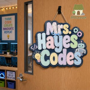 May include: A decorative wooden door sign with a dark blue wood-grain background featuring the text Mrs. Hayes Codes in multi-colored pastel patterned letters. The sign includes a light blue bow, a lightbulb icon, a robot, and code brackets.