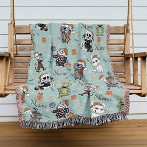 A colorful throw blanket with various cartoon characters and holiday-themed designs, including Santa Claus, a skeleton, and other festive elements, is hanging on a wooden bench.