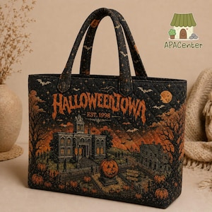 May include: A black quilted tote bag featuring an orange graphic print of a town scene with the text HALLOWEENTOWN EST. 1998. The design includes a large pumpkin, silhouettes of trees, buildings, bats, and stars against a dark background.