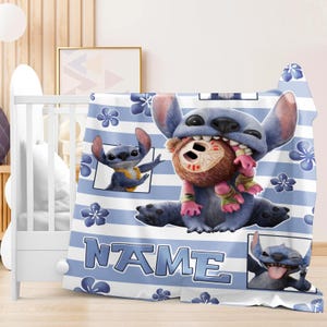May include: A blue and white striped blanket featuring the character Stitch from Lilo & Stitch. The blanket has a repeating floral pattern and the word "NAME" in large blue letters. Stitch is shown in several poses.