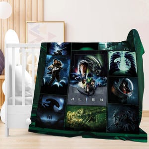 May include: A green and black fleece blanket featuring a collage of images from the movie "Alien." The blanket displays various scenes and the word "ALIEN" in white block letters. The blanket is draped over a white crib.