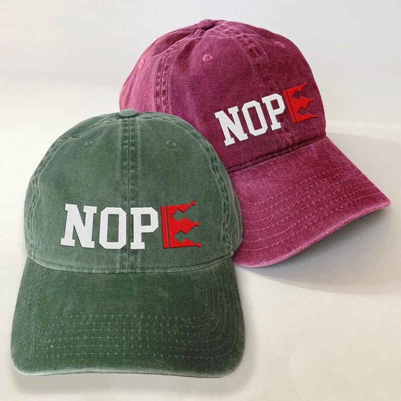 Two baseball caps, one green and one maroon, with the word "NOP" printed on them.