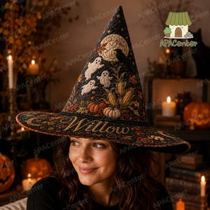 Puede incluir: Un sombrero de bruja puntiagudo de color negro con un intrincado patrón acolchado con fantasmas, una luna llena, mazorcas de maíz y calabazas bordadas. El ala muestra el nombre Willow en elegantes letras doradas, con hojas de otoño.