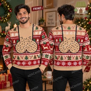 Puede incluir: Un suéter de manga larga y cuello redondo en color beige con un patrón navideño rojo y blanco de renos, árboles de Navidad y copos de nieve. El centro del suéter muestra un gráfico grande, beige y texturizado de dos formas redondeadas.