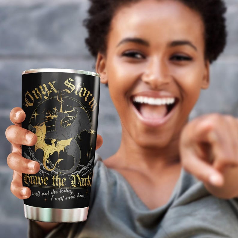 May include: A black stainless steel tumbler with a gold design featuring a dragon and the text "Onyx Storm Brave the Dark I will not die today, I will save him."