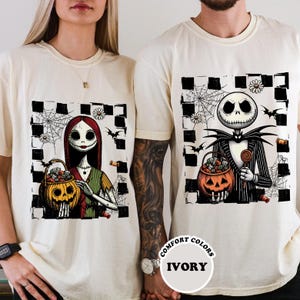 A woman and a man wearing white t-shirts with Halloween-themed illustrations of Jack Skellington and Mary Jane.