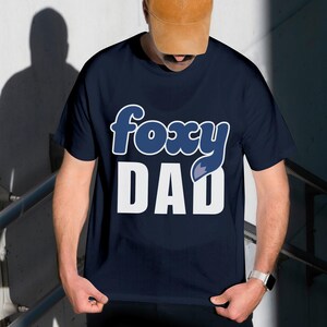 A man wearing a blue t-shirt with the text "FOXY DAD" printed on it.