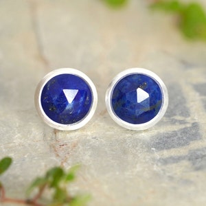 Peut inclure: Une paire de boucles d'oreilles en argent avec des pierres rondes en lapis-lazuli bleu.