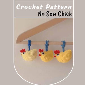 Pode incluir: Três enfeites de pintinho de crochê amarelo com cristas vermelhas e laços azuis pendurados são exibidos em um cabide de madeira. O texto "Crochet Pattern No Sew Chick" está na parte superior da imagem.