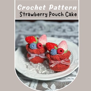 May include: Two crocheted strawberry pouch cakes on a white plate. Each red pouch is adorned with a red and white gingham ribbon and topped with crocheted strawberries, blueberries, and raspberries. The text "Crochet Pattern Strawberry Pouch Cake" is at the top.