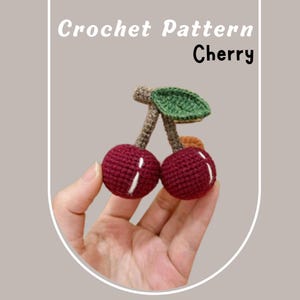 Peut inclure: Modèle de crochet pour une cerise. Le modèle comprend deux cerises rouges avec des feuilles vertes et des tiges brunes.