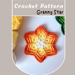 May include: A crocheted star-shaped granny square in shades of orange, yellow, and white. The center of the star features a smaller white flower.