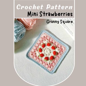 Puede incluir: Un cuadrado de granny crochet con un centro rosa y blanco y un borde azul. El centro presenta un diseño de fresas rojas.