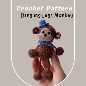 Puede incluir: Un mono de crochet marrón con piernas colgantes, que lleva un sombrero azul y una pajarita a cuadros azul y blanco. Patrón de crochet para un mono con piernas colgantes.